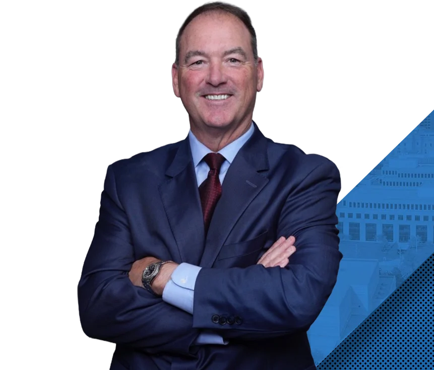 Attorney Trevor Crossen, arms crossed, smiling in a navy suit